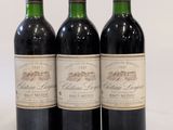 trois bouteilles de vin rouge sont alignées sur une surface blanche