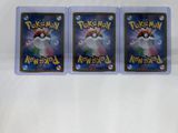 three pokemon cards are sitting on a white surface