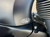 un gros plan d'une moto noire ornée d'un emblème chromé