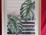 Reproduction d'un Monstera delicioosa dans un cadre en bois sur une toile rouge