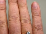 a person ' s hand with a diamond ring on it