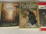 trois livres posés sur une table, avec un chien au milieu