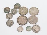 quelques vieilles pièces de monnaie sont posées sur une surface blanche, sur fond blanc