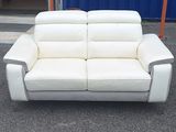 un canapé en cuir blanc posé devant un conteneur bleu