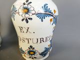 un vase blanc orné de fleurs bleues et jaunes