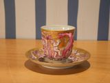 a cup and saucer sitting on a wooden table
