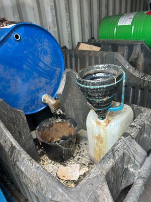 a blue barrel sitting next to two green barrels