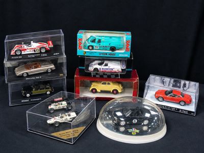 cinq modèles réduits de voitures différents dans une vitrine sur fond noir