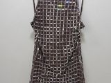 une robe marron et blanche suspendue à un cintre accroché au mur