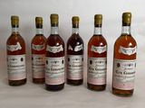 six bottles of wine are lined up on a table