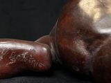a close up of a statue of a person laying on a black surface