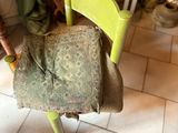 a green chair with a cushion on it in a room