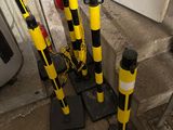 plusieurs cônes de signalisation jaunes et noirs posés par terre à côté d'une borne d'incendie