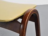a wooden chair with a yellow cushion on it