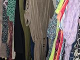 a lot of clothes hanging on a rack in a closet