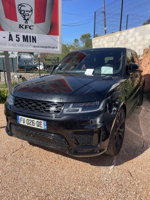 a black range rover parked in front of a large sign