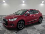 une citrole rouge garee sur un plancher en damier dans un garage
