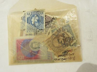 un sachet de timbres posé sur une table, à côté d'une feuille de papier