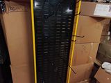 une machine noire et jaune dans un entrepôt rempli de cartons