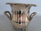 a silver vase that is sitting on a table