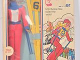 une vieille figurine représentant un skieur, dans une boîte avec ses skis
