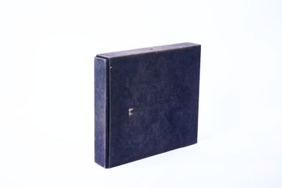 un livre noir posé sur une surface blanche