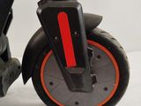a black scooter with orange wheels on a white surface