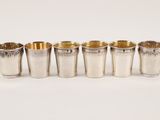 a set of six silver shot glasses in various sizes and shapes