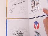 une personne tenant un livre sur lequel figurent des dessins de voitures