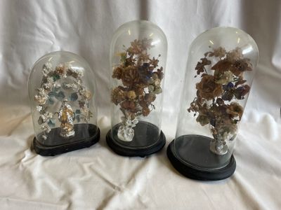 trois cloches en verre contenant différents types de roches