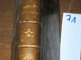 un vieux livre posé sur une table, à côté d'une feuille de papier