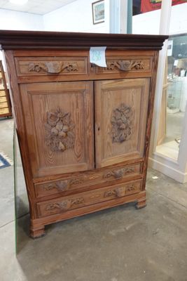 une armoire en bois ornée de sculptures, dans un magasin
