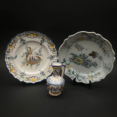 trois types d'assiettes différents et un vase posés sur un fond noir
