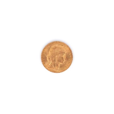 gros plan d'une pièce d'or sur une surface blanche