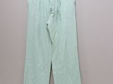 the green pants are hanging on a hanger on a wall