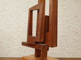 sculpture made of wood on a wooden table against a white wall