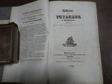 un livre ouvert sur une table, à côté d'un portefeuille