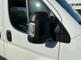 an image of a side view mirror of a white van