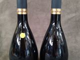 deux bouteilles de vin posées sur une table l'une à côté de l'autre
