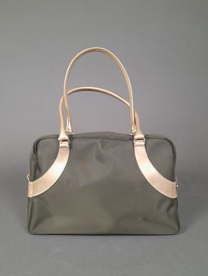 the large grey and gold bag is sitting on a gray surface