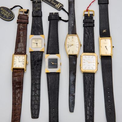 four different types of wrist watches are lined up on a table