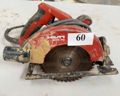 une scie circulaire rouge posée sur une table blanche