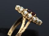 a close up of a gold ring with pearls and garnets