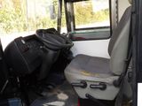 a red and white bus with a seat and a steering wheel