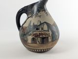 un vase noir et blanc orné d'une illustration représentant une scène de vie à la ferme