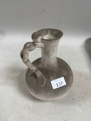 un petit vase muni d'une étiquette, posé sur une table