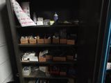 a black cabinet with many items in it in a room