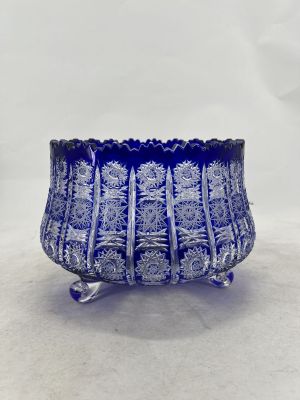 a close up of a blue glass bowl on a white surface