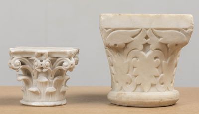 two white vases sitting on a table next to each other