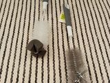 a picture of a cleaning brush and a duster on a striped rug